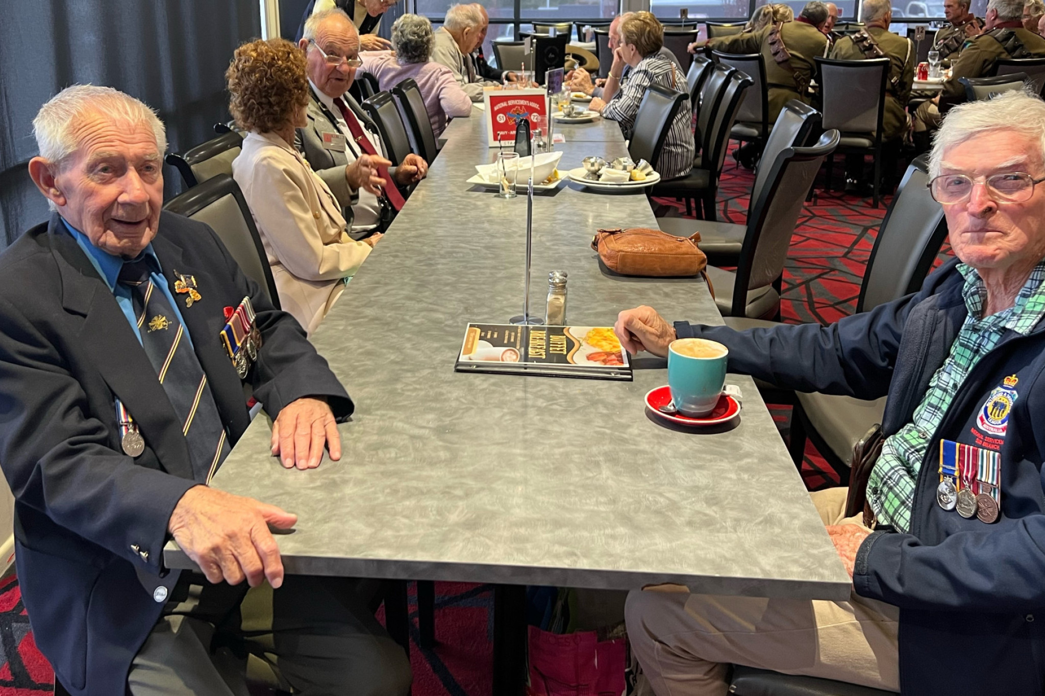 Des Fossey (left) and Cec Mitchell share lunch and memories with 25th Battalion members as often as they can, especially on April 25.