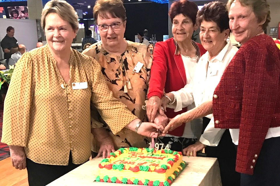 Former St Joseph's School teachers - (from left) Pamela Sullivan, Clare Bonner, Eileen Williamson, Judy Lee and Margaret Martin - cutting the reunion cake iced in the "Mercy colours" of red, yellow and green.